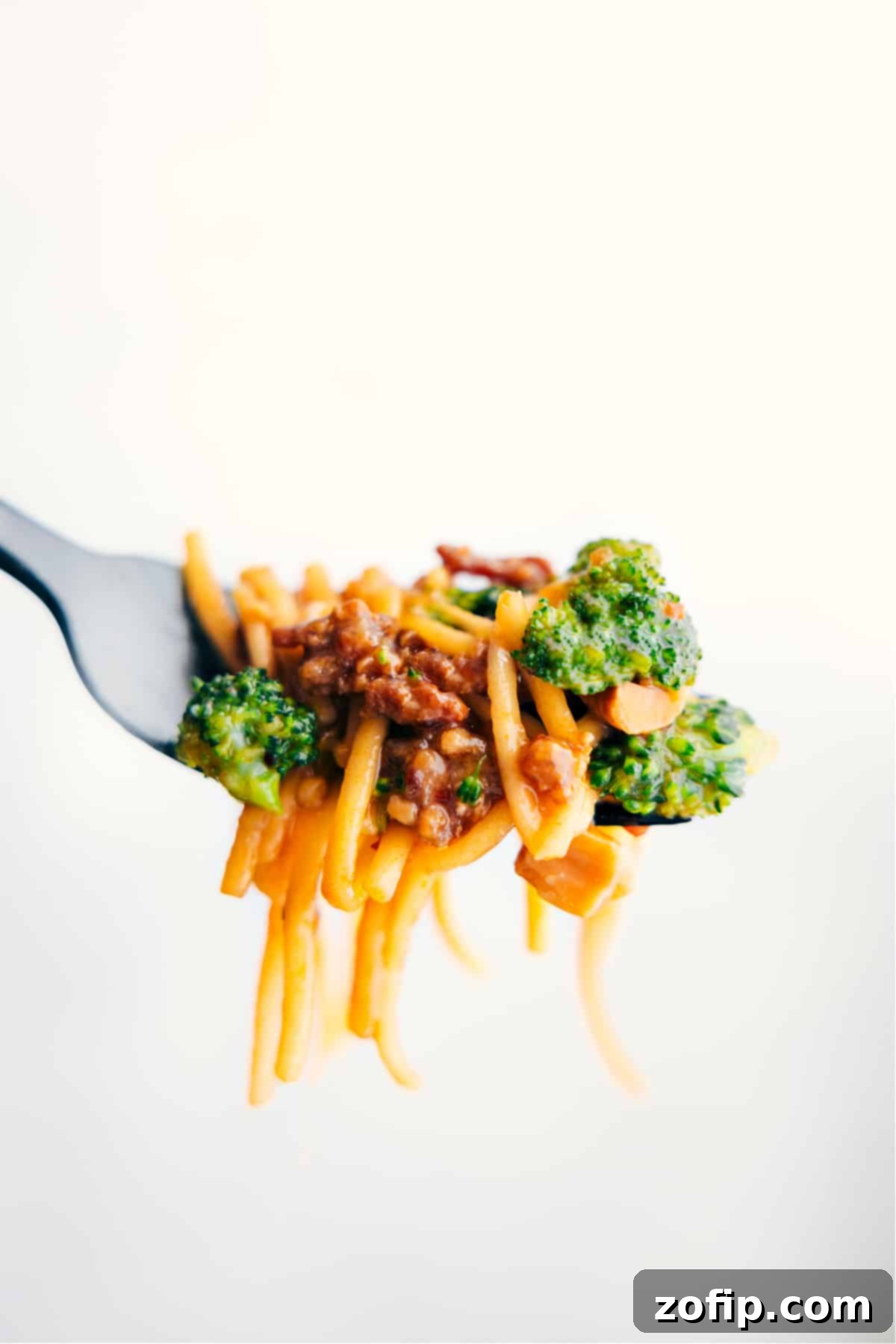 Fiery Dragon Noodles 2 A close-up shot of a steaming bowl of Dragon Noodles, generously garnished with green onions and cashews, ready to be enjoyed.