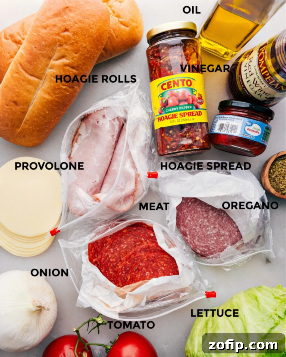All the fresh ingredients for Italian Hoagies prepped and laid out for easy assembly, including sliced meats, cheese, and vegetables.