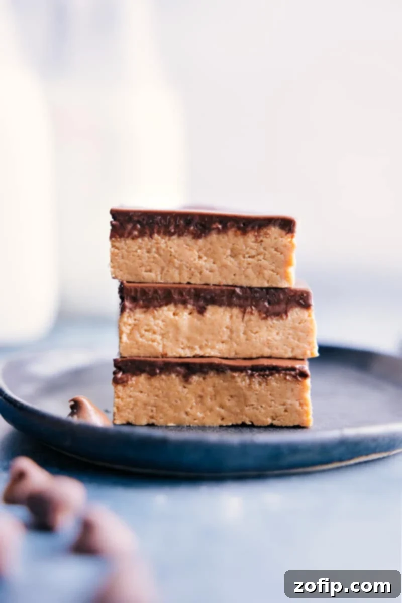 Image of the Peanut Butter Bars stacked on top of each other, showcasing the thick peanut butter layer and chocolate topping