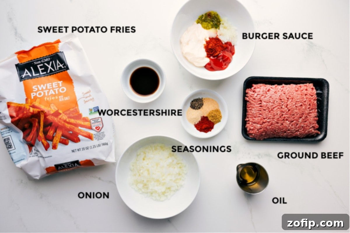 Ingredients In This Burger Bowl Recipe All essential ingredients for the Burger Bowl laid out: sweet potato fries, burger sauce in a jar, Worcestershire sauce, a blend of spices, raw ground beef, olive oil, and a whole yellow onion, showcasing fresh preparation.