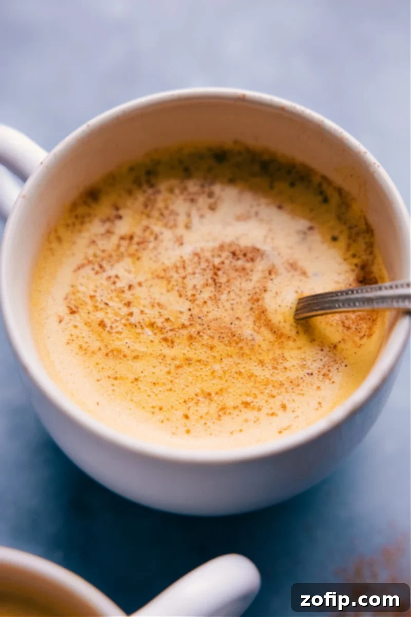 Overhead image of Golden Milk in a mug, garnished with cinnamon stick