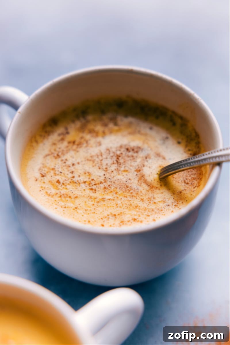 Image of Golden Milk ready to be served in two mugs with cinnamon stick garnish