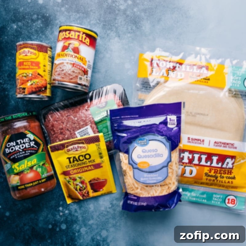 This simple Tortilla Pie layers tortillas with creamy refried beans, taco-seasoned beef, saucy salsa, and plenty of melty cheese. Recipe via ChelseasMessyApron #dinner #quick #easy #simple #best #familyfriendly #kidfriendly #tortilla #pie A flat lay image displaying all the essential ingredients for making Tortilla Pie: flour tortillas, ground beef, taco seasoning, enchilada sauce, shredded cheese, salsa, and refried beans.