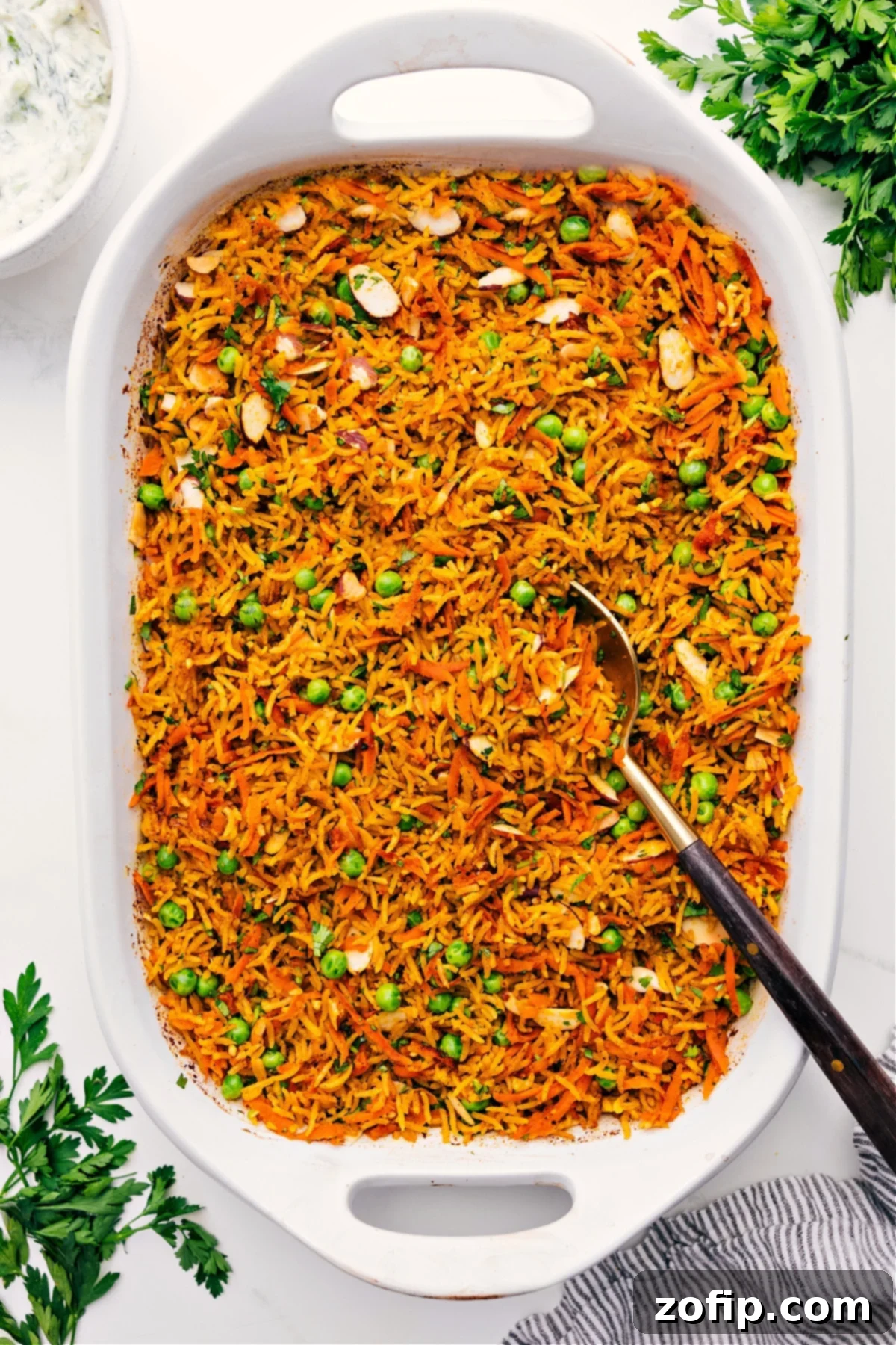 Perfectly Cooked One-Pan Curry Rice Delicious Curry Rice in a baking dish with a serving spoon, highlighting its fluffy texture and rich colors.
