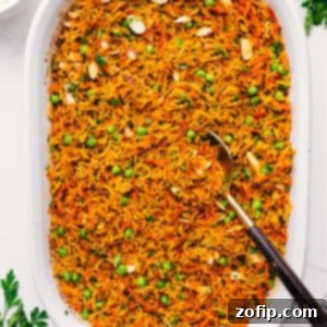 Delicious One Pan Curry Rice 3 A vibrant bowl of freshly cooked Curry Rice, garnished with fresh cilantro and a dollop of tzatziki sauce.