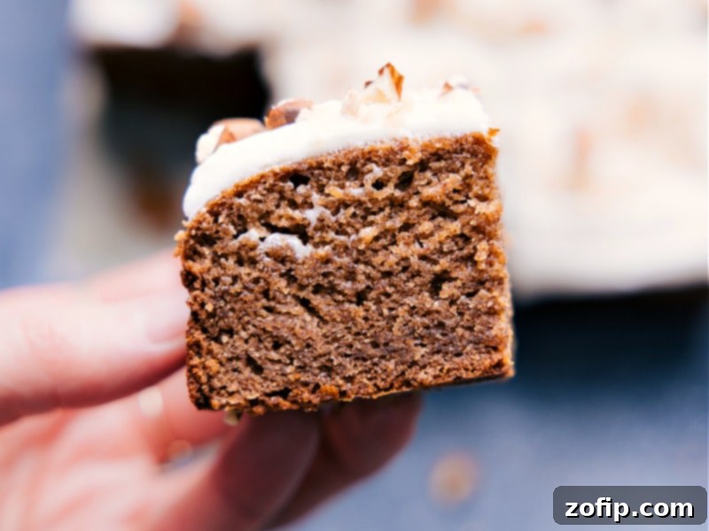 Close-up view of Healthy Banana Cake with textured cream cheese frosting, showing the rich brown spots of the banana cake.