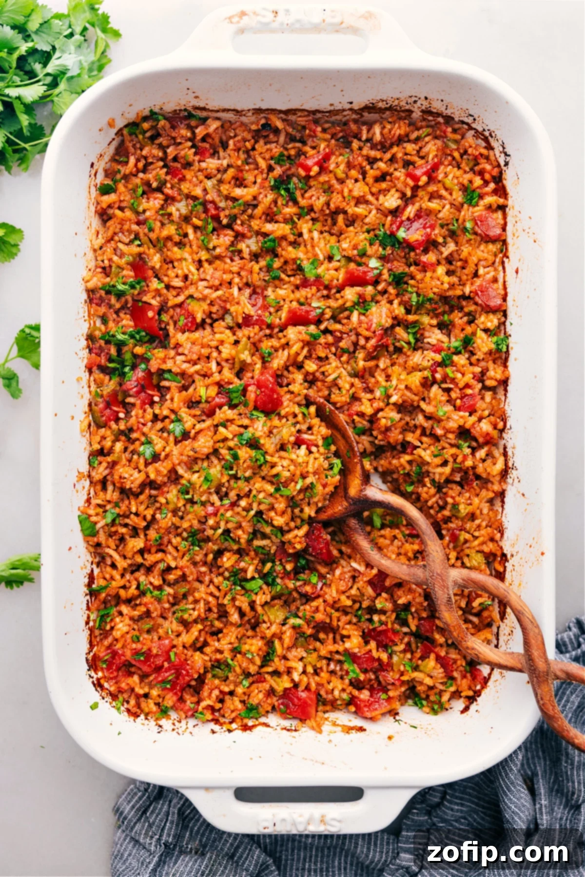 A vibrant and perfectly cooked Mexican Rice Recipe, fresh out of the oven in a ceramic baking pan, garnished with fresh cilantro.
