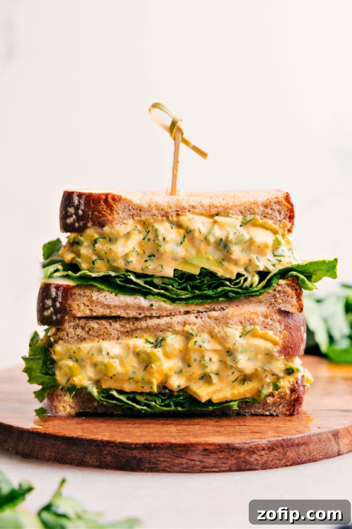 Perfectly stacked egg salad sandwiches, showcasing a generous filling and fresh ingredients, ready to be enjoyed.