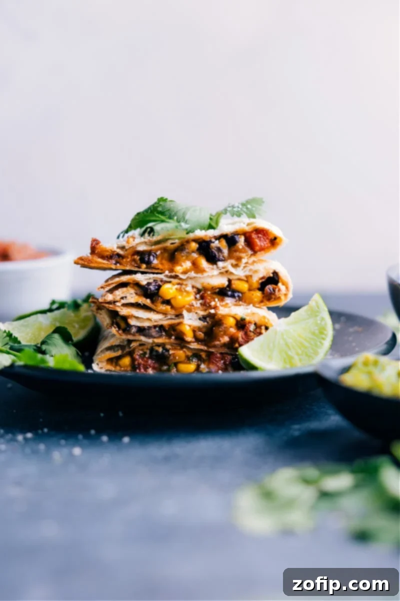 Black Bean Quesadillas cut into triangles and neatly arranged on a white plate, garnished with fresh cilantro.