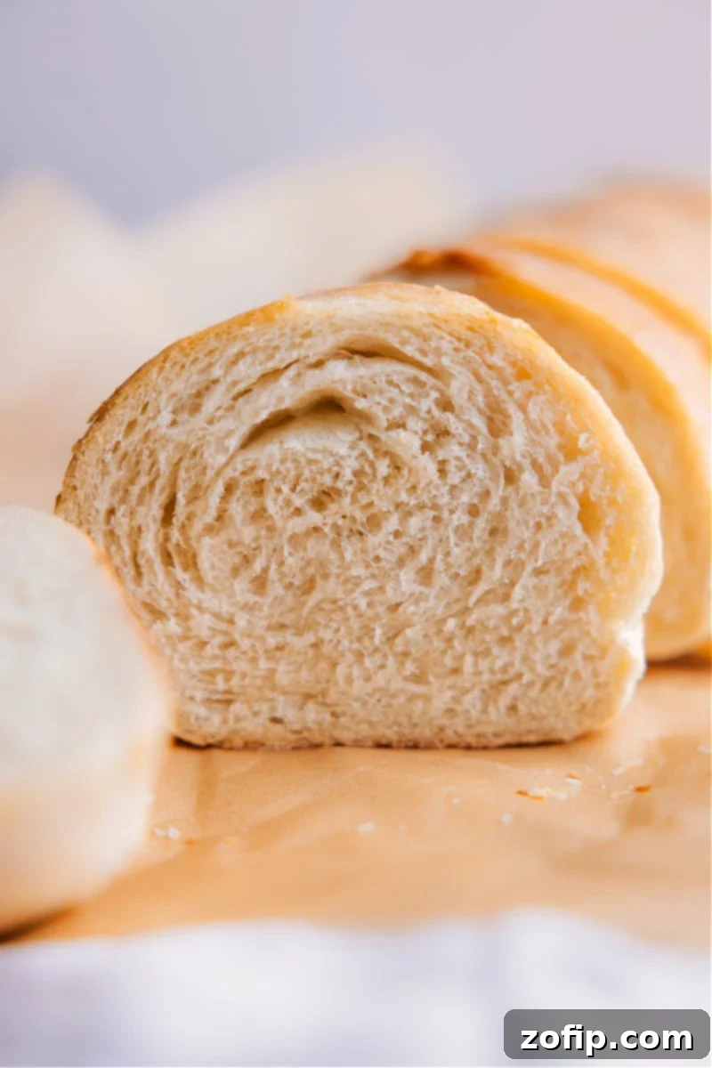 Image of a slice of the French bread, showcasing its light and airy interior and golden, crusty exterior.
