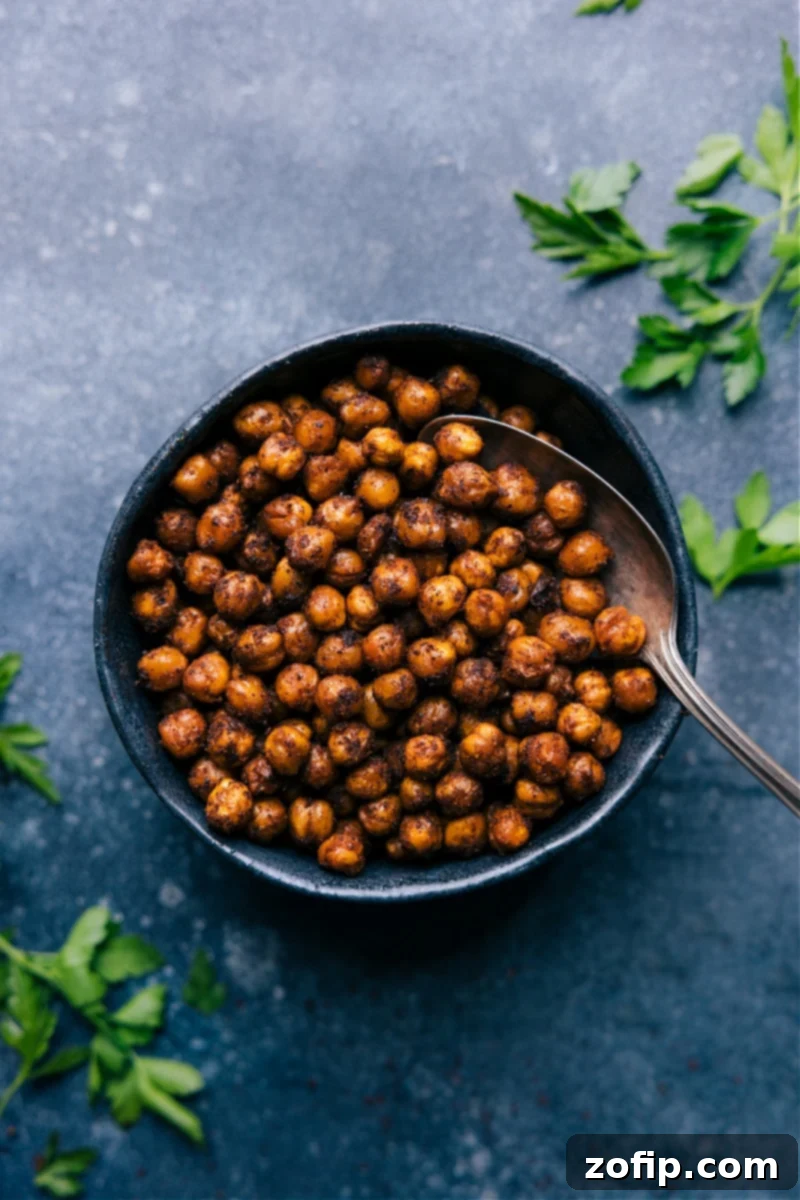 Overhead image of freshly prepared Air Fryer Chickpeas in a rustic bowl, garnished with fresh herbs, showcasing their golden-brown and crispy texture.
