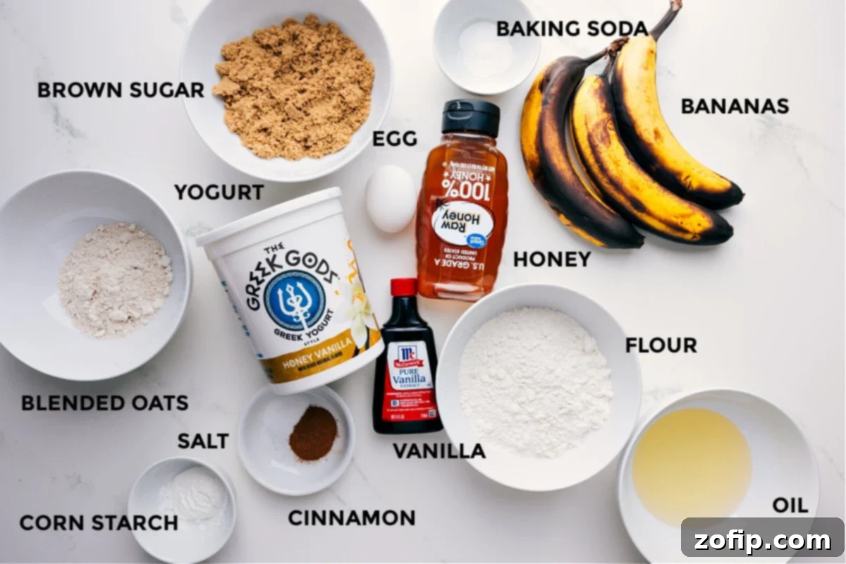 All essential ingredients for the Greek yogurt banana bread laid out on a counter, including ripe bananas, Greek yogurt, flour, brown sugar, eggs, and spices, ready for mixing and baking.