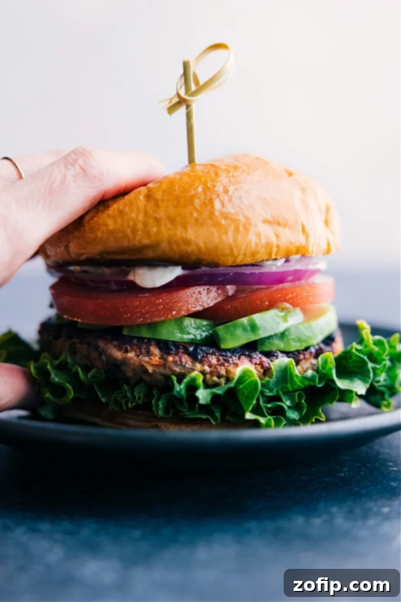 The Best Veggie Burger Recipe: A Culinary Masterpiece A stack of homemade veggie burgers, beautifully assembled with fresh lettuce, creamy avocado, ripe tomatoes, thinly sliced red onions, a dollop of special sauce, all nestled within a soft, toasted bun.