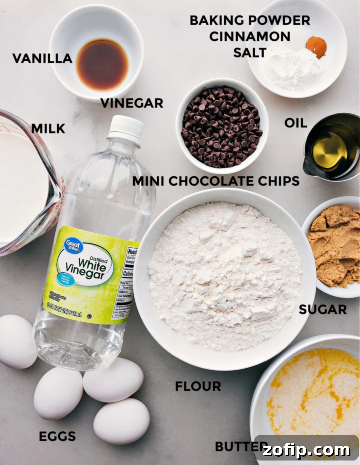 All the essential ingredients for making chocolate chip waffles meticulously prepped and laid out for easy assembly, including flour, eggs, milk, butter, and chocolate chips.