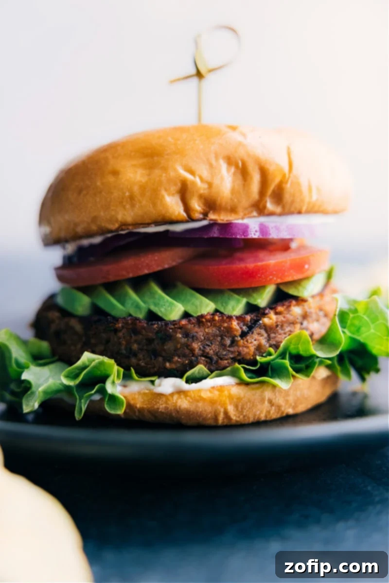 Delicious Sweet Potato Black Bean Burger served on a bun with fresh toppings on a plate, showcasing its hearty texture.