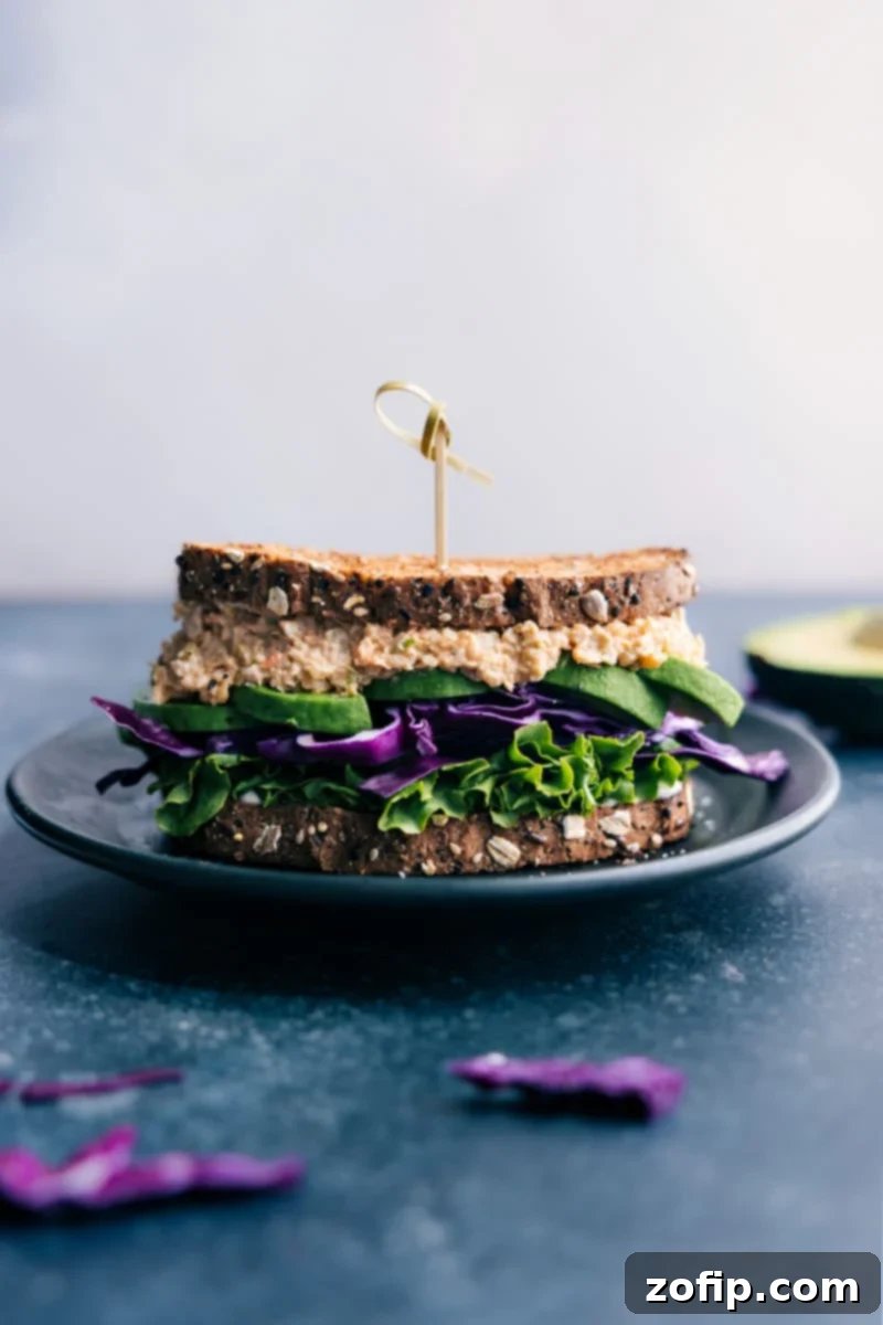 Delicious and easy Buffalo Chickpea Salad Sandwich recipe – perfect for quick lunches, dinners, or meal prep. A vegetarian, spicy, and satisfying plant-based meal from ChelseasMessyApron. Image of a Buffalo Chickpea Salad Sandwich on a plate, garnished with fresh greens