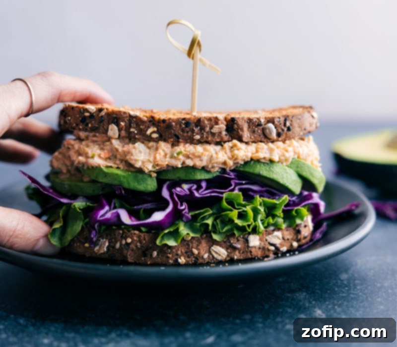 The finished Buffalo Chickpea Salad Sandwich, a robustly flavored, healthy, and quick vegetarian meal, ready to eat. Recipe via ChelseasMessyApron. Image of a Buffalo Chickpea Salad Sandwich, halved and ready to be enjoyed