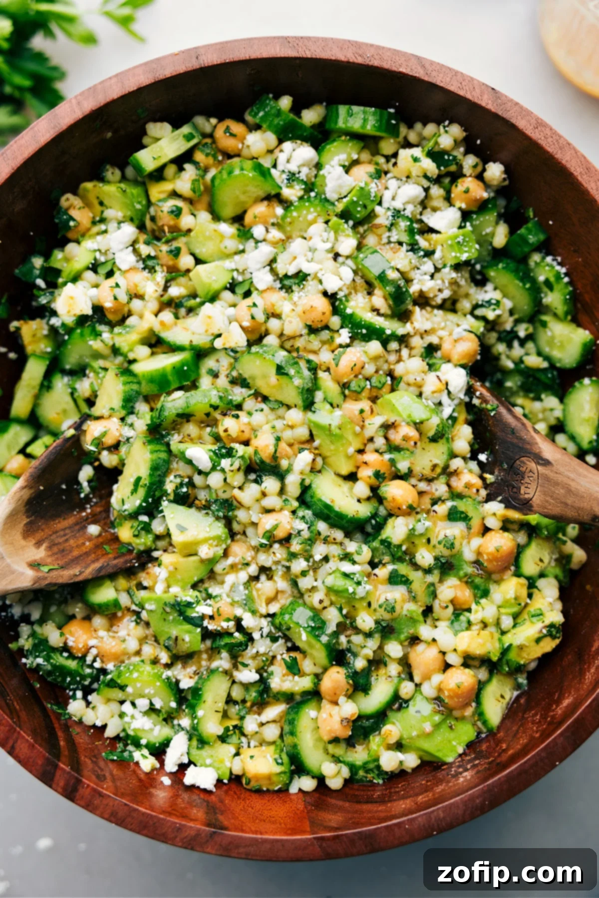 Cucumber feta salad tossed with dressing and ready to be served in a large bowl.