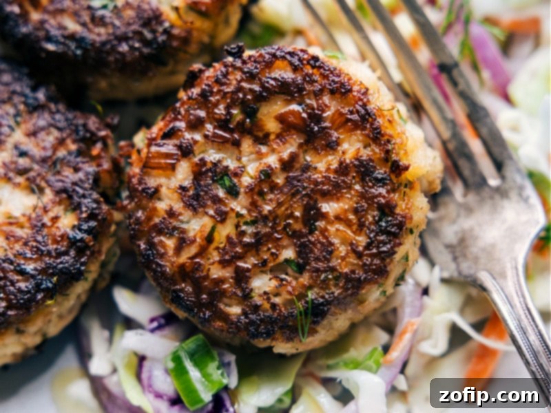 A close-up view of the best Tuna Patties, showcasing their perfectly crispy texture and inviting golden-brown hue. Up close image of golden brown Tuna Patties on a plate