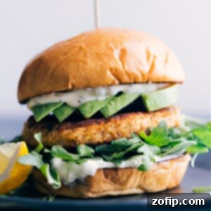 Close-up of a perfectly cooked salmon burger patty on a toasted bun with fresh toppings.