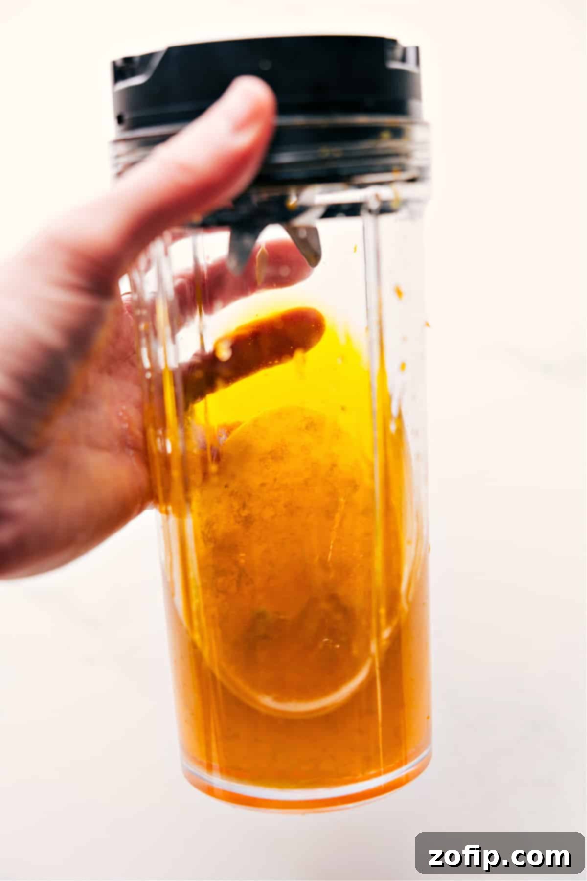 All the citrus dressing ingredients, including clementines, lemon, honey, Dijon mustard, olive oil, and salt, are placed into a blender and processed until they form a smooth, emulsified vinaigrette, ready to enhance the peach salad.