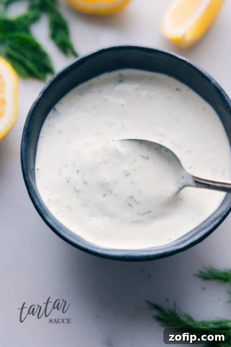 Overhead image of a beautifully presented bowl of creamy, tangy homemade Tartar Sauce, garnished with a sprinkle of fresh dill, ready to serve.