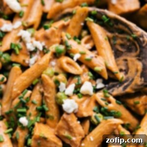 Zesty Buffalo Chicken Pasta 2 Close-up of a serving of Buffalo Chicken Pasta garnished with blue cheese and green onions.