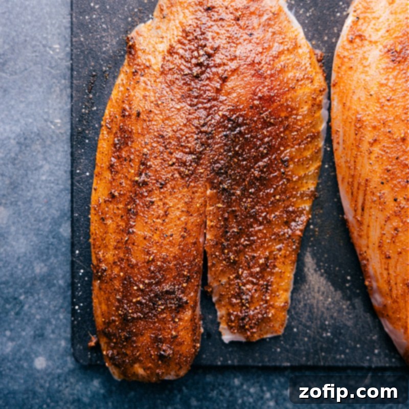 Overhead image of seasoned tilapia fillets ready to be placed into the air fryer basket.