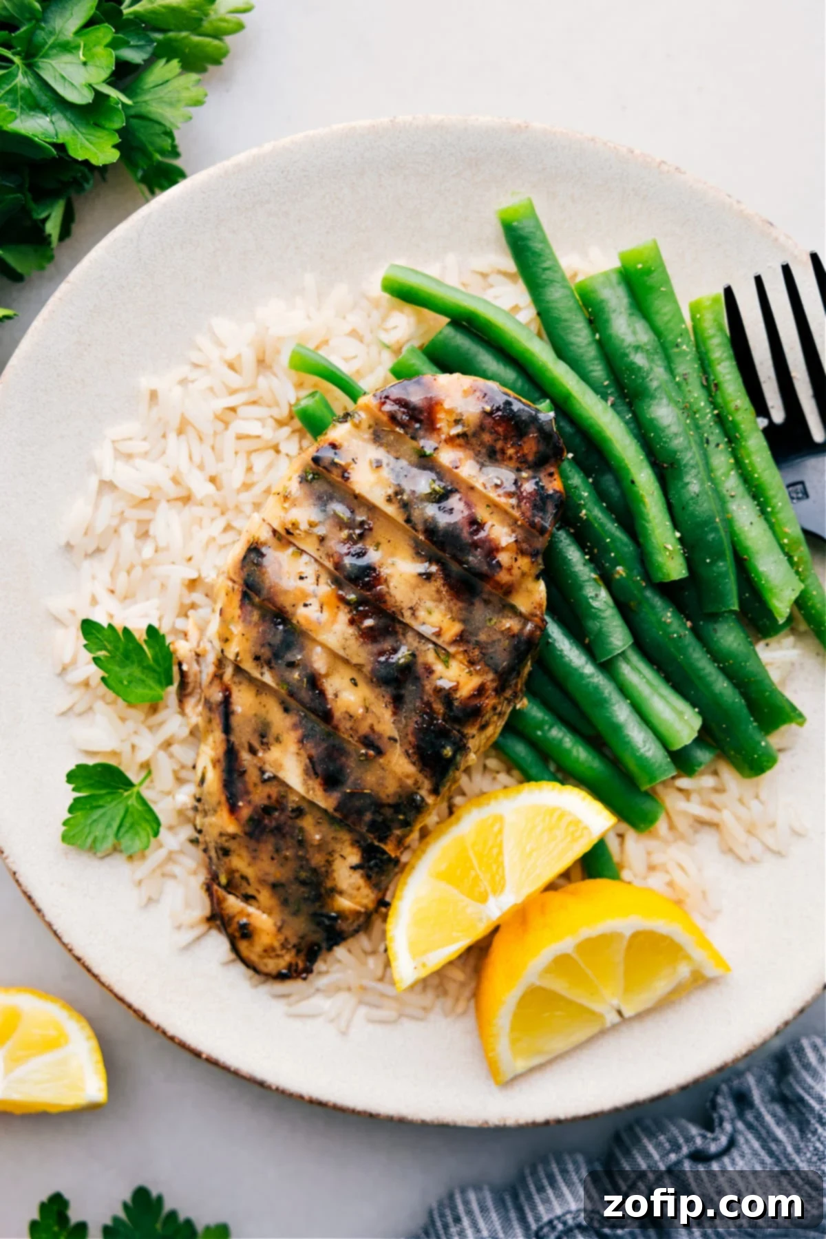 Perfectly grilled Italian Chicken Marinade served on a bed of rice with green beans, showcasing a delicious and healthy meal.