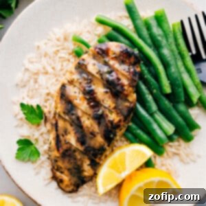 Italian Chicken Marinade recipe on a plate over a bed of rice with green beans.