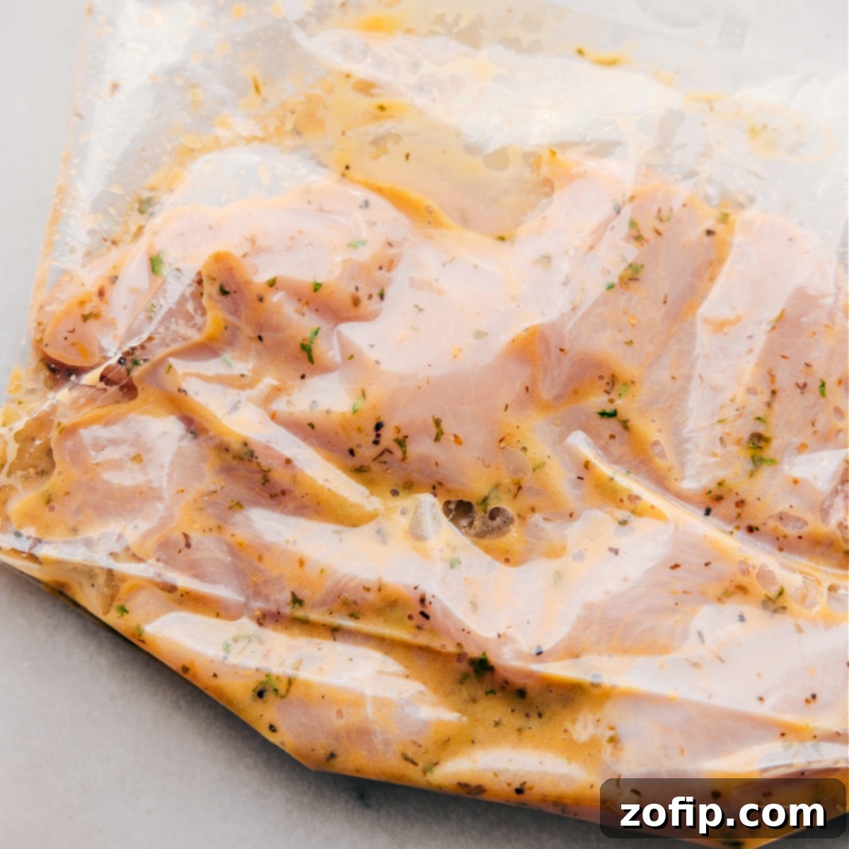 Chicken breasts marinating thoroughly in the Italian dressing inside a freezer-size bag, ready for cooking.