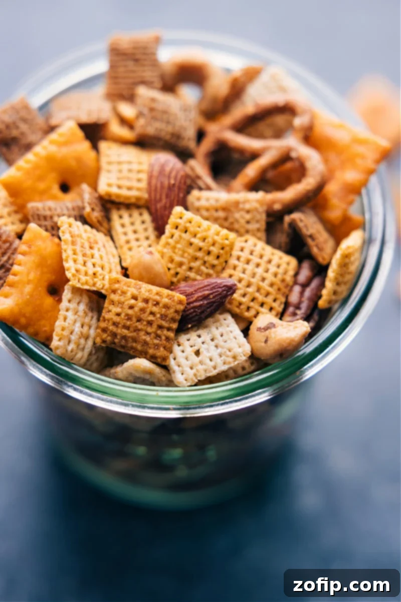 Overhead view of a large bowl filled with golden-brown, perfectly seasoned Chex Mix, featuring visible pieces of cereal, pretzels, cheese crackers, and nuts.