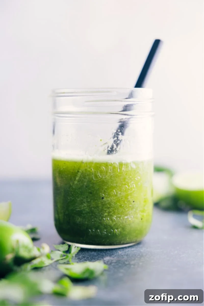 This bright and vibrant Cilantro Lime Dressing owes its flavor to fresh lime juice and citrusy cilantro. Plus it's easy to prepare -- simply throw everything into a blender and let it whirl! This naturally vegan, dairy-free, and gluten-free Cilantro Lime Dressing checks all the nutrition boxes. Recipe via chelseasmessyapron #dressing #quick #easy #simple #best #fresh #healthy #cilantro #lime #vinagrette Image of the vibrant green cilantro lime vinaigrette in a serving bowl, ready to be drizzled over a meal.