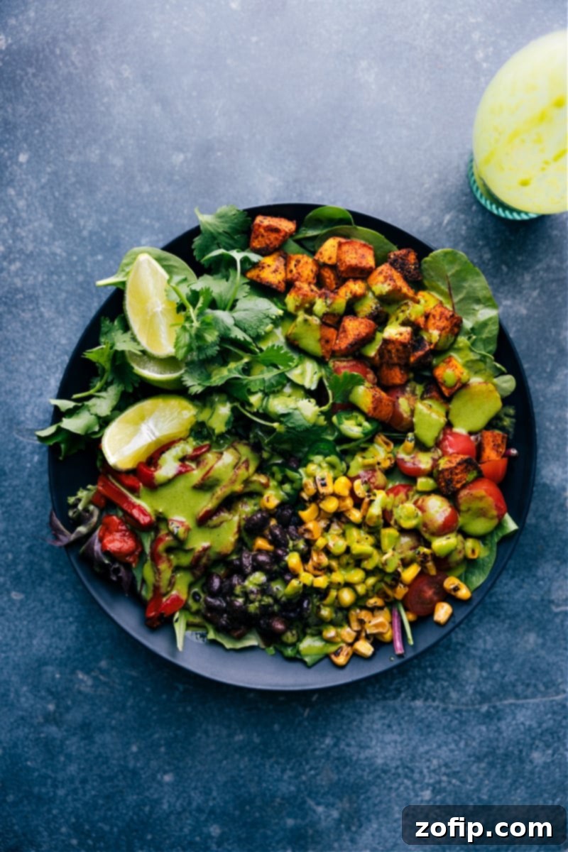 This bright and vibrant Cilantro Lime Dressing owes its flavor to fresh lime juice and citrusy cilantro. Plus it's easy to prepare -- simply throw everything into a blender and let it whirl! This naturally vegan, dairy-free, and gluten-free Cilantro Lime Dressing checks all the nutrition boxes. Recipe via ChelseasMessyApron.com #cilantrolime #cilantro #lime #citrusy #glutenfree #vegan #dairyfree #salads Overhead view of a vibrant salad in a white bowl with Cilantro Lime Dressing generously drizzled over it, showcasing a delightful meal.