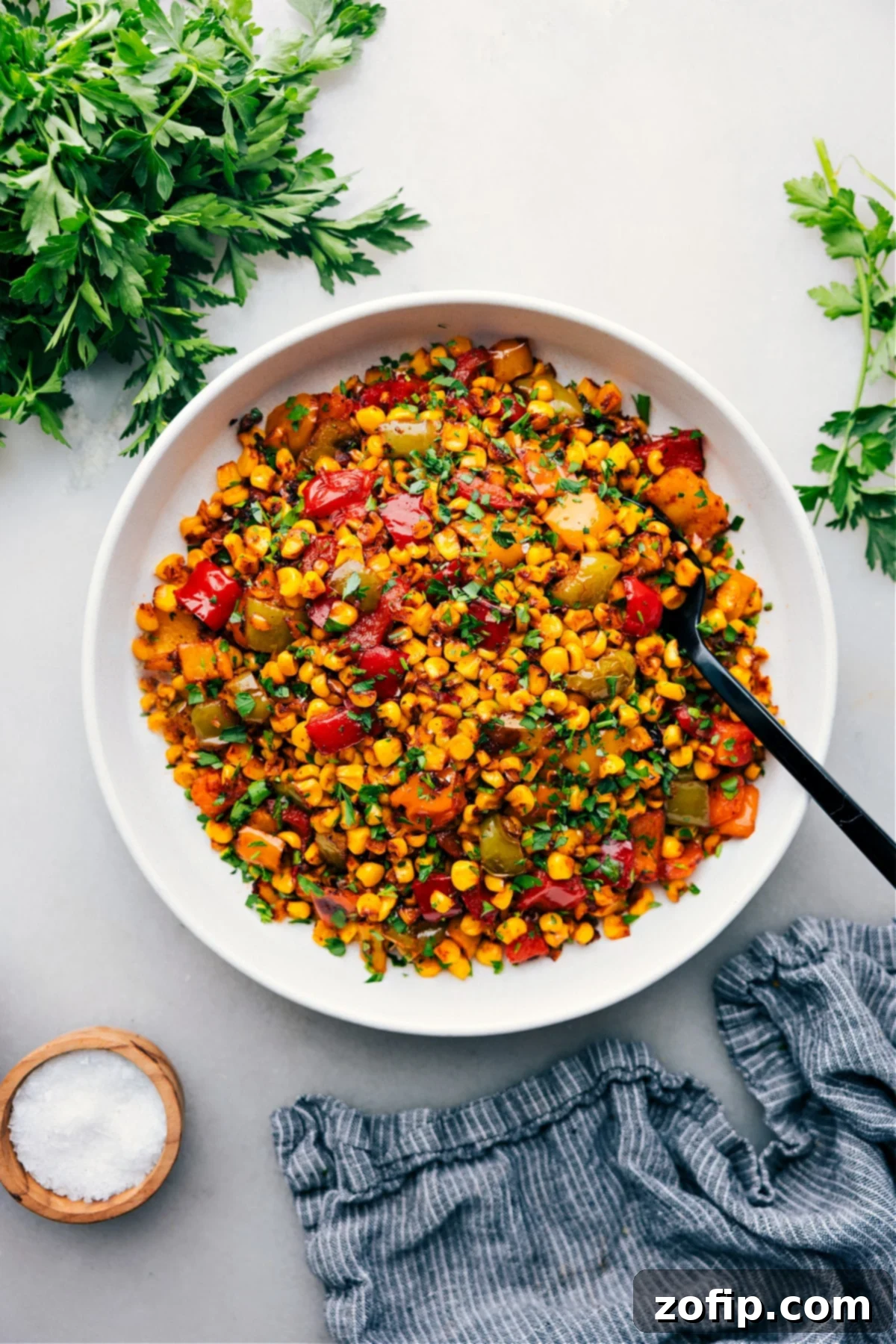 Roasted Corn in a bowl ready to be served at your next BBQ or summer event, garnished with fresh herbs.