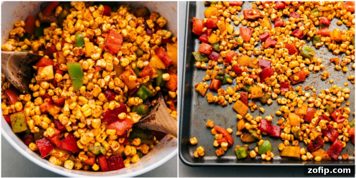 All the corn kernels and diced bell peppers tossed with olive oil and spices, spread evenly on a sheet pan, ready for roasting.
