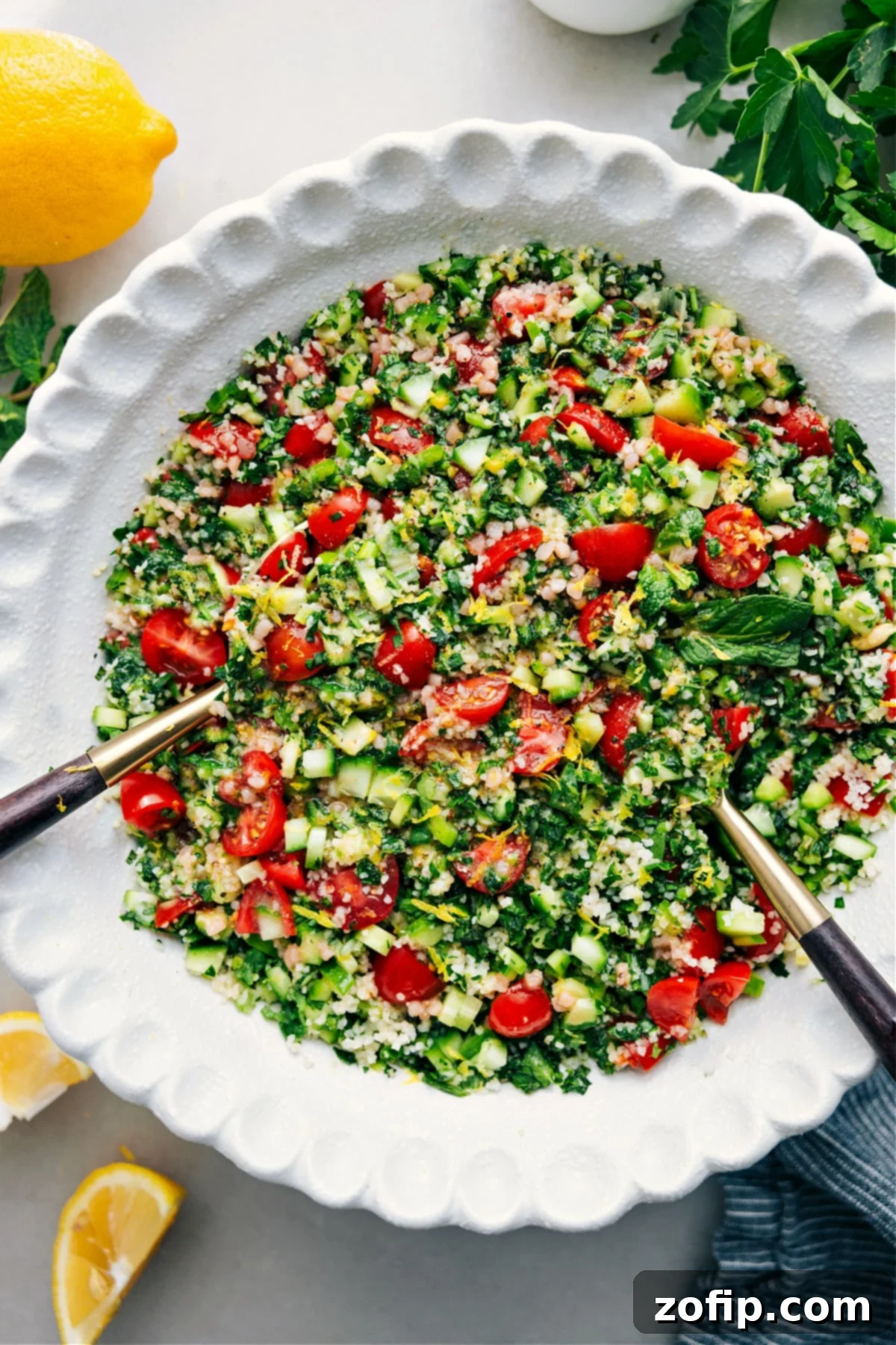 A vibrant bowl of Tabouli salad, tossed with dressing and ready to be enjoyed, showcasing fresh green herbs, red tomatoes, and bulgur.