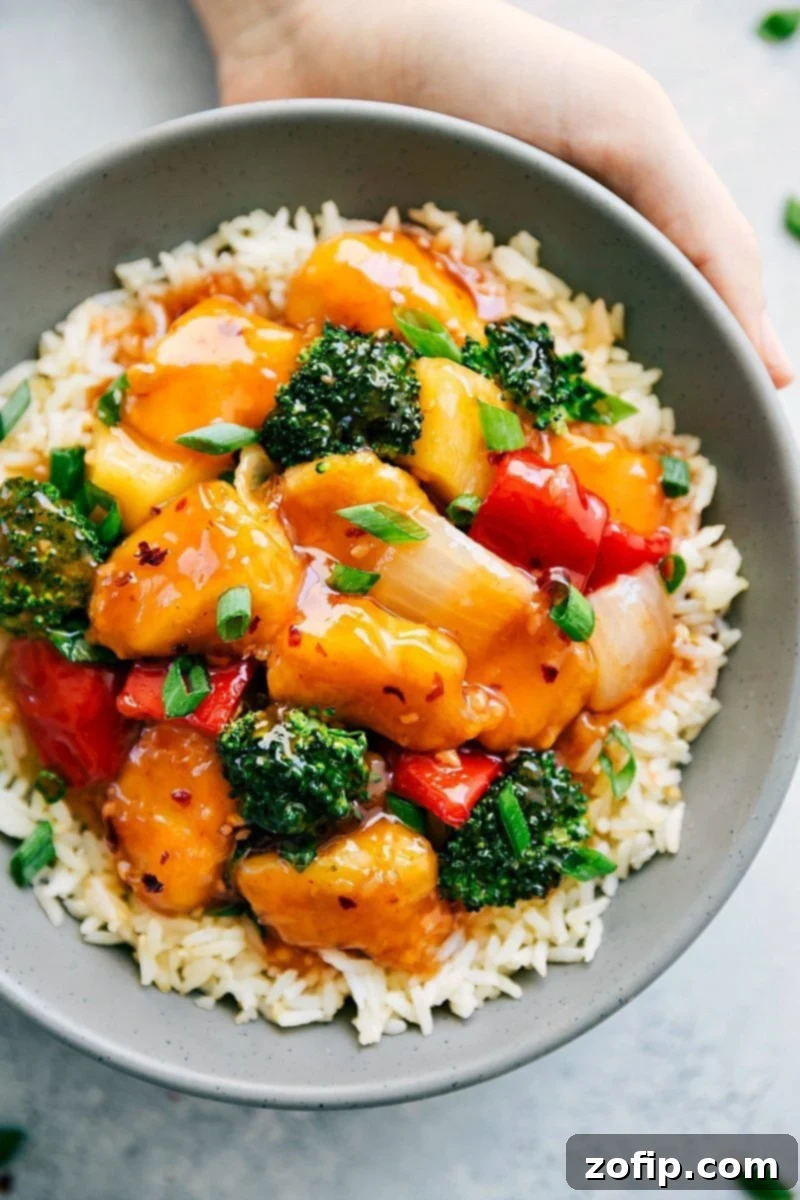 Sweet and Sour Chicken brings the restaurant favorite to your dinner table! Overhead view of Sweet and Sour Chicken, showcasing crispy chicken, vibrant broccoli, and pineapple chunks in a rich sweet and sour sauce, served over rice.