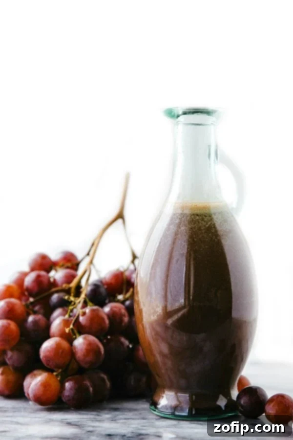 Cherry Balsamic Salad Dressing with Fresh Grapes Cherry balsamic salad dressing in a container, accompanied by fresh grapes for a delicious salad.