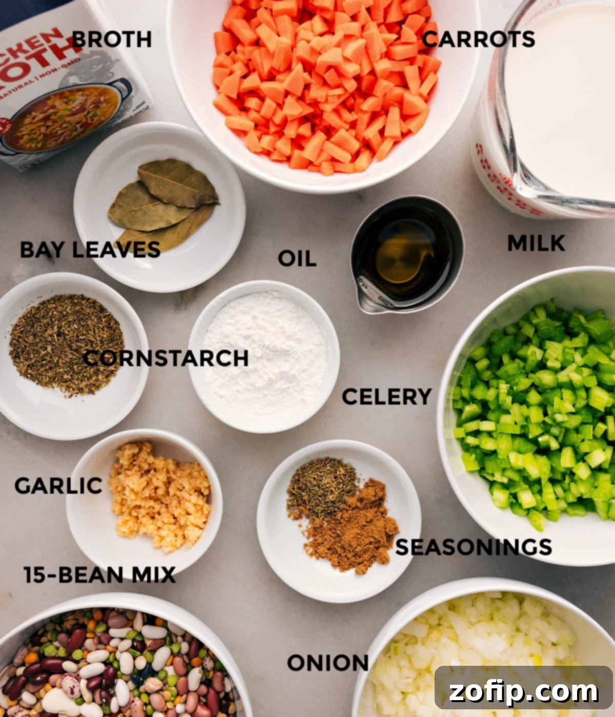 All the ingredients are prepped for easy assembly—veggies, milk, bay leaves, beans, garlic, cornstarch, seasonings, and broth.