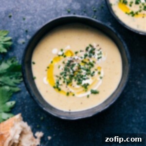 A bowl of creamy Potato Leek Soup, garnished with fresh herbs, ready to be served.