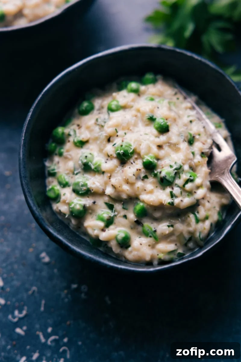 A close-up of creamy Instant Pot Risotto in a white bowl, garnished with fresh herbs.
