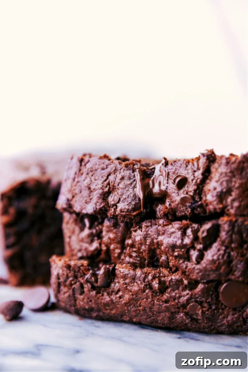 Stacked slices of rich chocolate banana bread, showing its moist texture and chocolate chips.