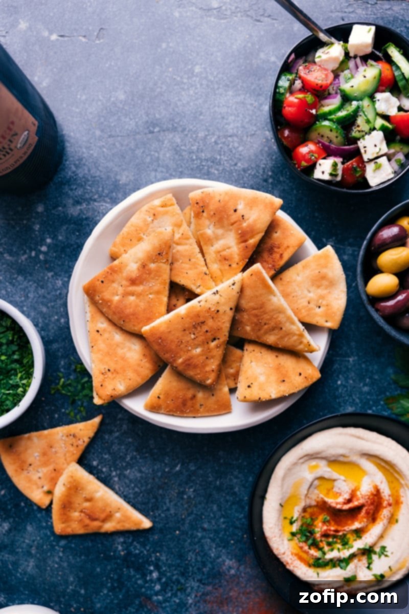 Delicious homemade pita chips, golden and crispy, are perfect for any Mediterranean spread or dip. #appetizer #best #quick #easy #simple #snacks #pita #chips Overhead image of golden brown homemade Pita Chips arranged on a plate, ready for dipping.