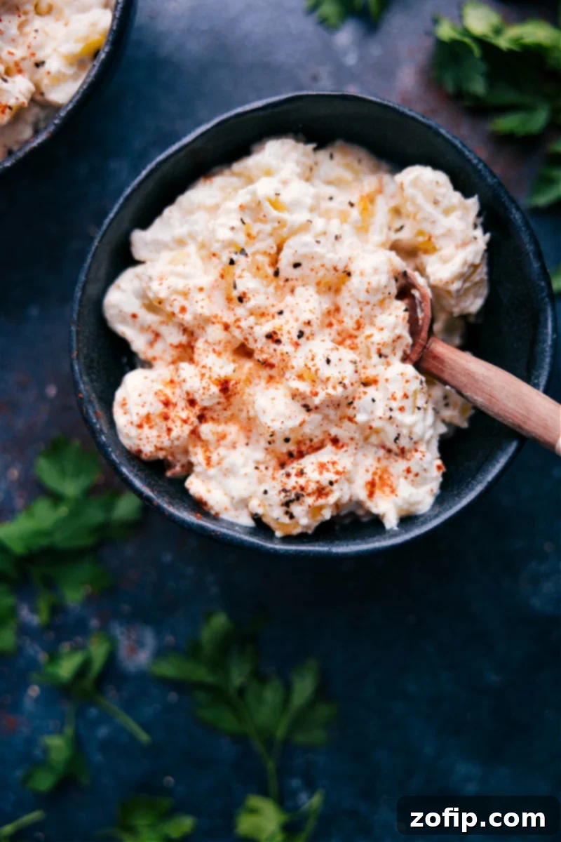 View of Creamed Potatoes in a serving bowl, sprinkled with paprika and herbs