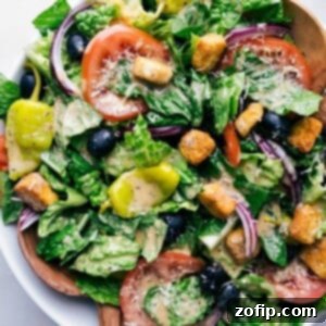 Olive garden salad beautifully dressed and prepared for a delightful meal, featuring crisp lettuce, tomatoes, olives, and pepperoncini.