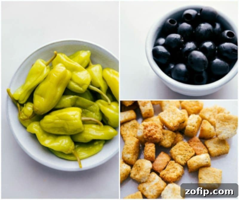 Essential ingredients for the Olive Garden Salad: bright green pepperoncini, golden garlic-herb croutons, and rich black olives, arranged to enhance the flavor profile and visual appeal.