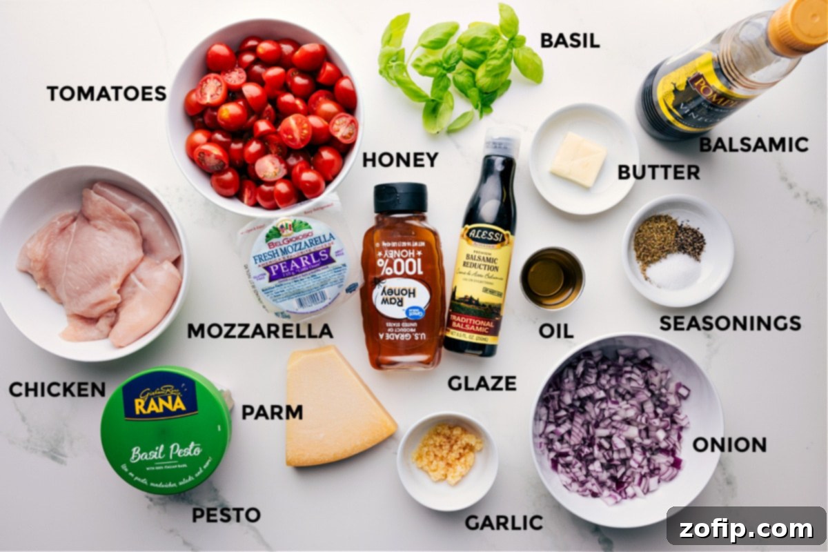 All the ingredients for this Caprese chicken recipe are prepped and ready for easy assembly, including fresh basil, chicken breasts, balsamic reduction, butter, Italian seasonings, red onion, olive oil, honey, minced garlic, Parmesan cheese, mozzarella pearls, basil pesto, and vibrant cherry tomatoes.
