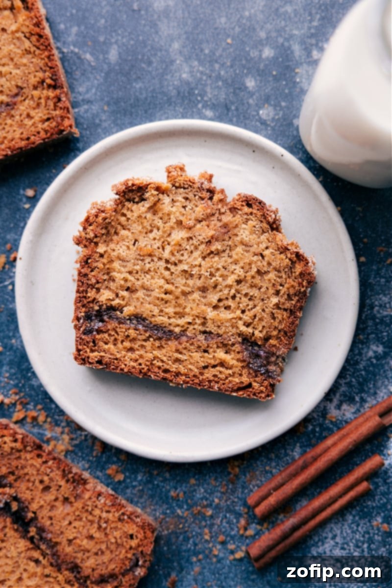 Overhead view of a beautiful, golden-brown Cinnamon Bread loaf, sliced to reveal its perfect cinnamon-sugar swirl and crunchy topping.