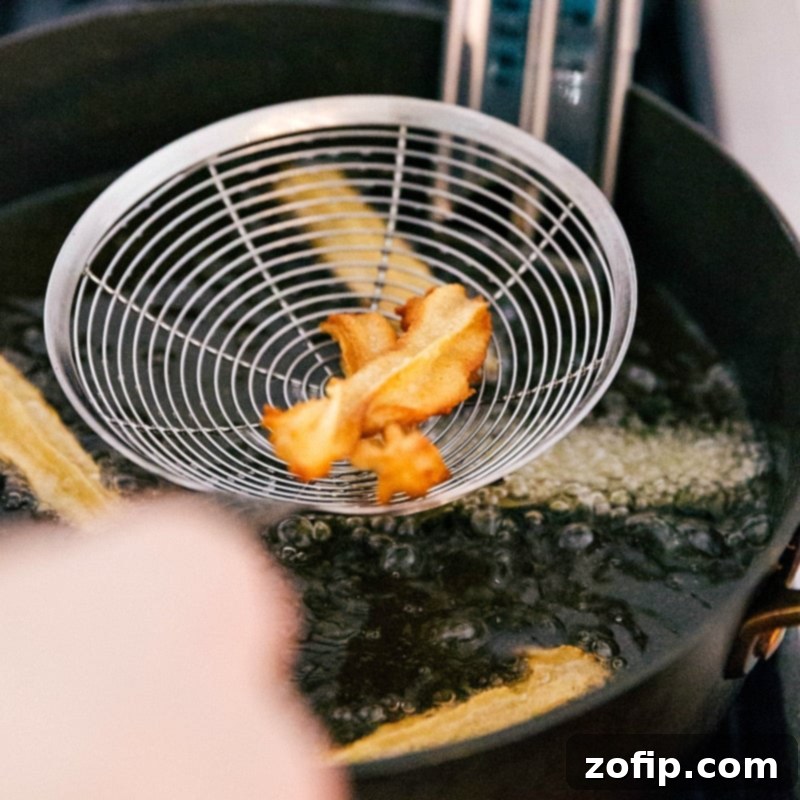Frying Churro Dough to Golden Crispy Perfection Dough frying to golden perfection in hot oil.